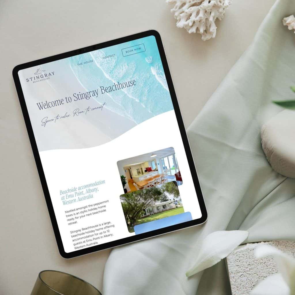 A tablet displays the Stingray Beachhouse website, featuring text, a beach-themed banner, and photos of accommodation and the property exterior.