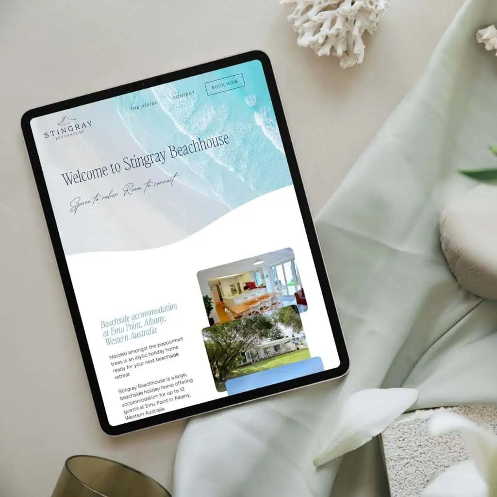 A tablet displays the Stingray Beachhouse website, featuring text, a beach-themed banner, and photos of accommodation and the property exterior.