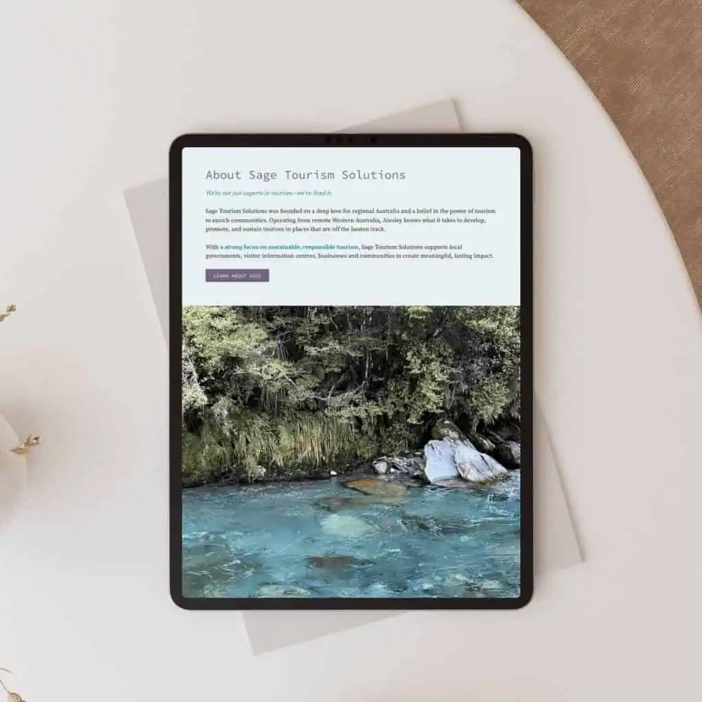 A tablet displaying a webpage for Sage Tourism Solutions, featuring text about the company and an image of a clear river with green foliage.