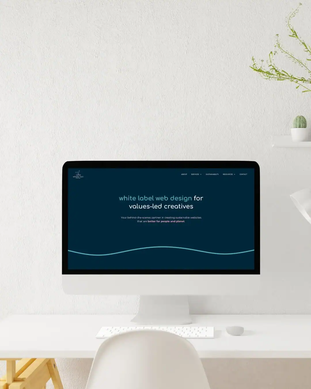A computer on a white desk displays a web design page with a navy background and white text, highlighting a bespoke sustainable website build tailored for solar companies.