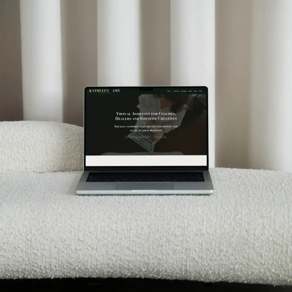 A laptop sits on a textured white sofa, displaying a website with text on a dark background.